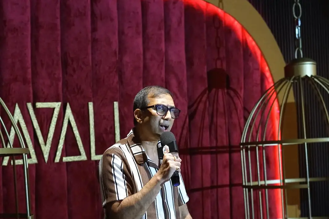An event host speaking into a microphone beside a lectern